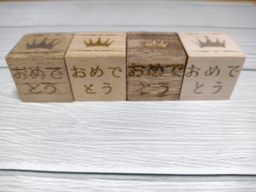 ウッドキューブは並べないがきっかけ。おめでとうを3㎝に収められるのはレーザー彫刻の強み